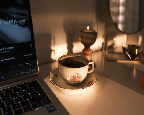 Laptop screen displaying warm evening light settings next to a cup of tea